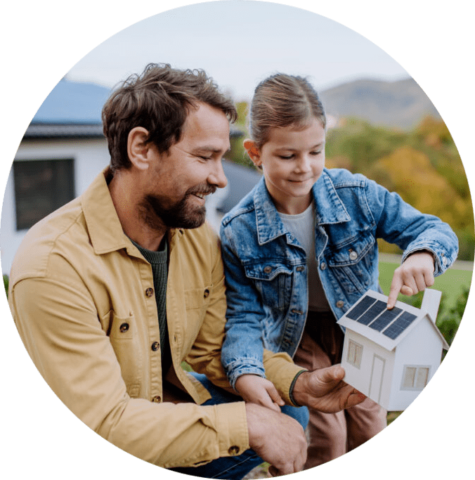 dad and daughter looking at a model of a home with a solar panel with solar panel house in background